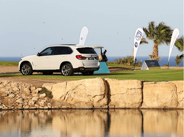 bmw-egypt-car-parked-on-golf-course-above-water-photo